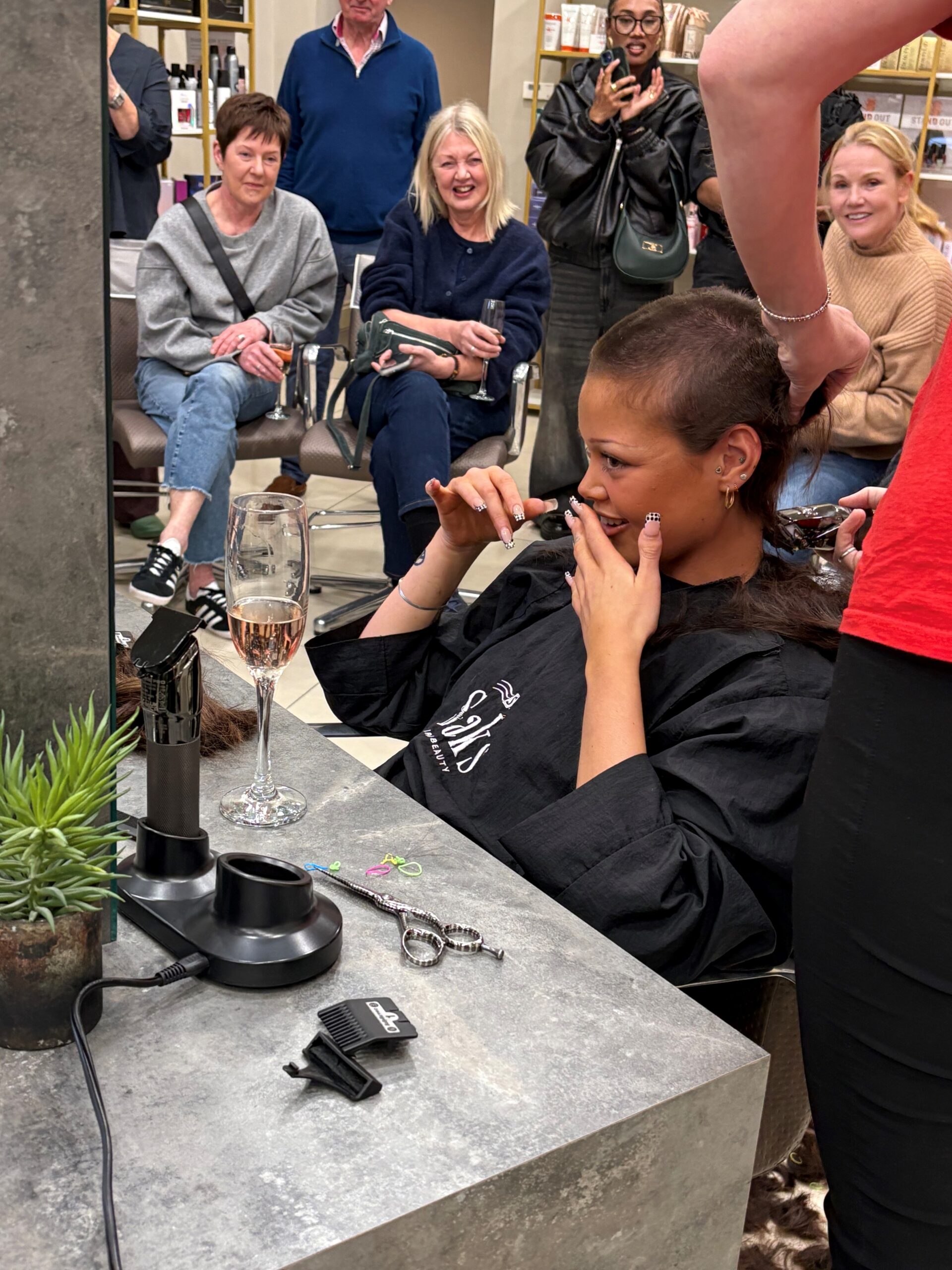 Izzy's proud moment shaving her hair for charity sat in the hair chair.