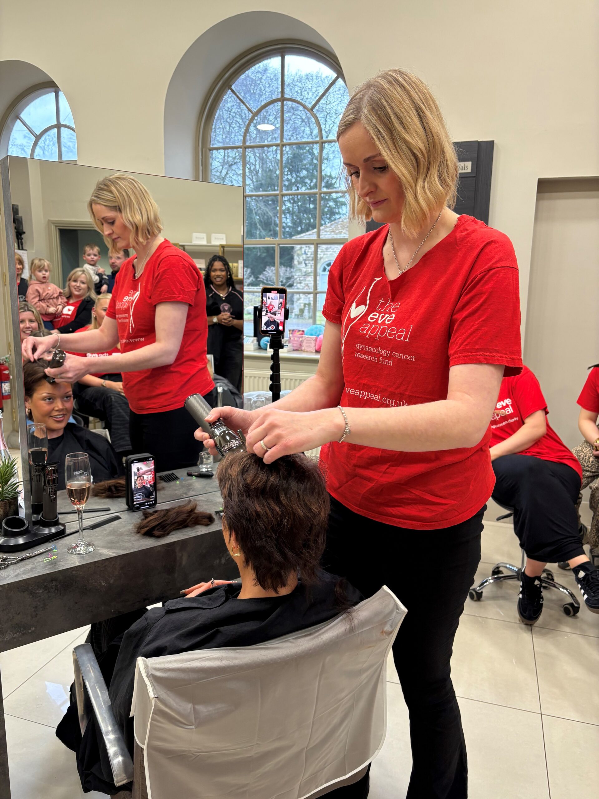 Laura, hair salon director from Saks Hair & Beauty Sedbury Hall shave's colleague, Izzy's head for charity of choice, The Eve Appeal