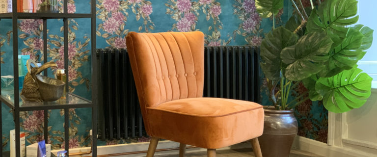 Image shows the interior of the Saks Barnard Castle hair salon, with a large orange chair.